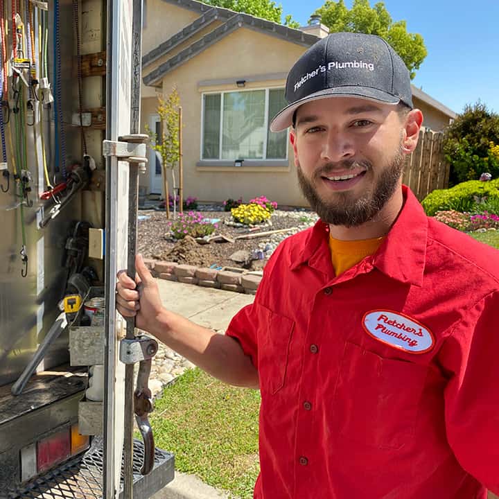 Plumber smiling at back of truck