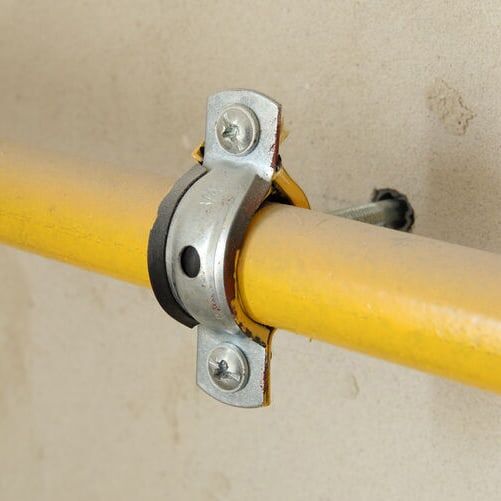 yellow gas line connected to wall with a fitting