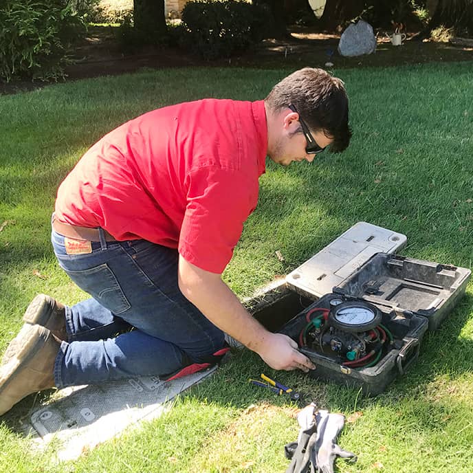 Technician with backflow testing equipment in residential area