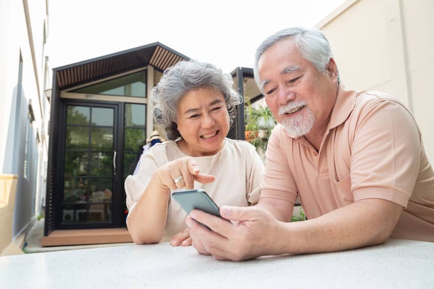 older couple looking at cell phone smiling