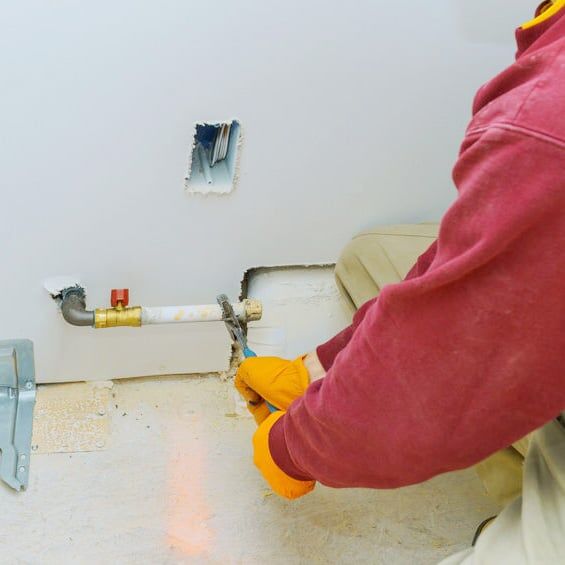 hands and wrench turning gas pipe fitting