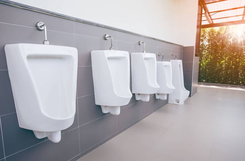 white urinals in a gray bathroom