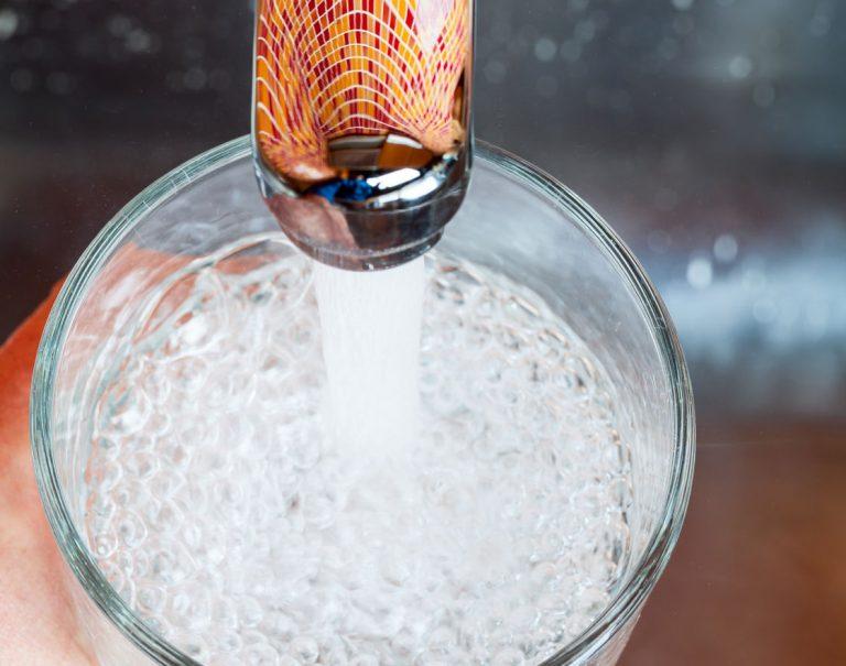 birds eye view close up of a glass being filled with water from a tap