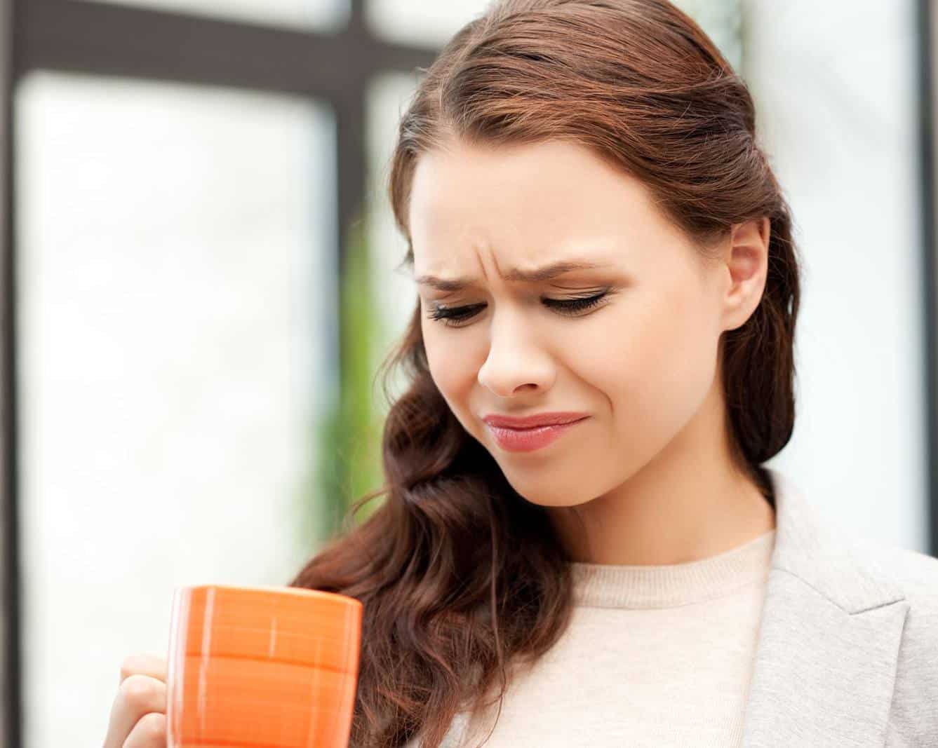 Concerned look on woman's face while looking into mug