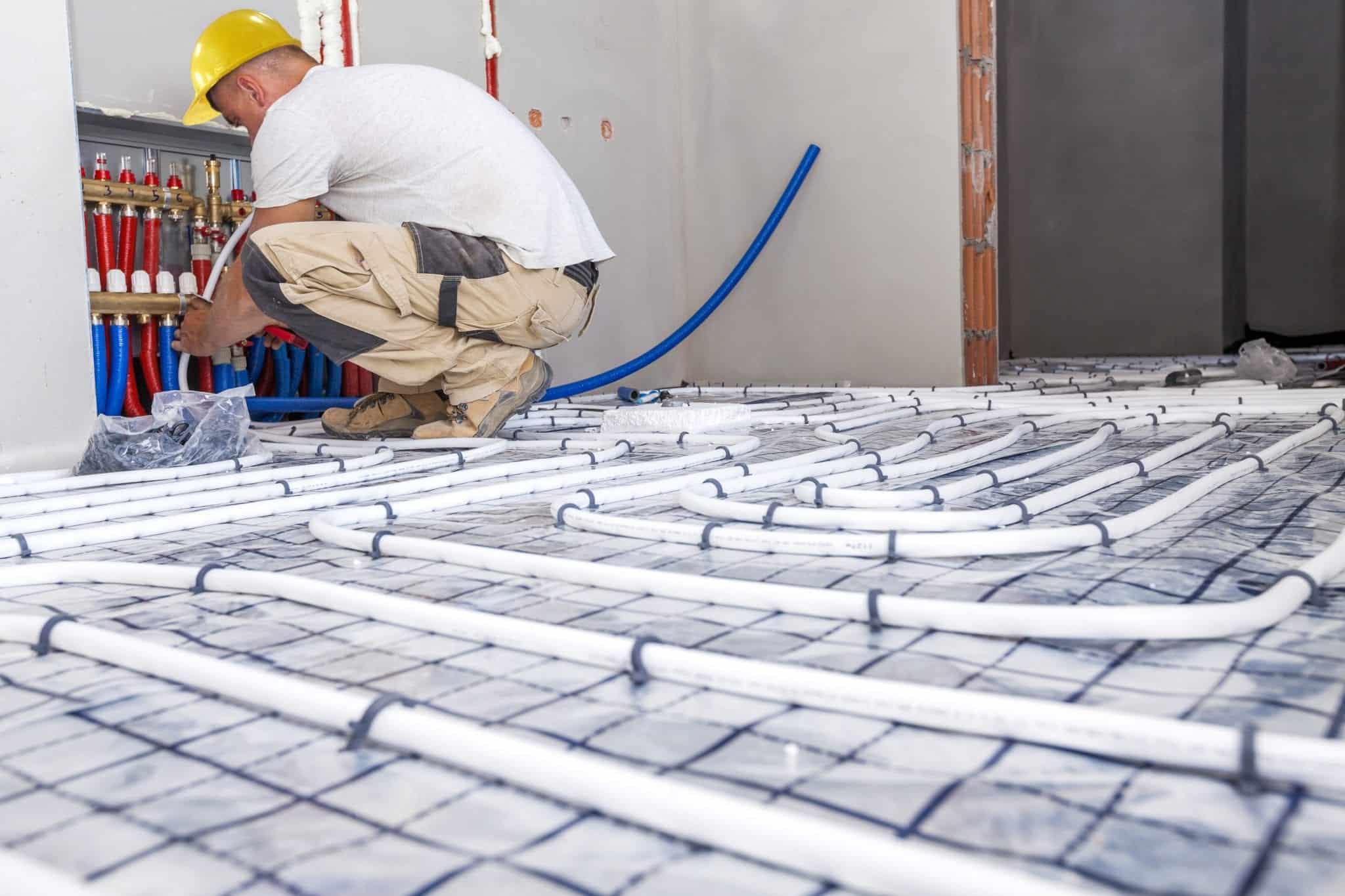 shutterstock_500711284 a man fixing pipe and wires