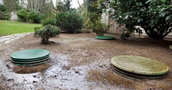 Water is leaking around the locking lids for a home's septic system tanks, creating a lot of mud in the yard.